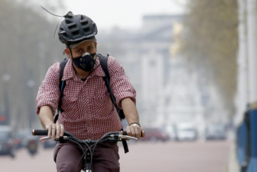 A cyclist wears a mask as he cycles near Buckingham Palace in London April 2, 2014. REUTERS/Luke MacGregor